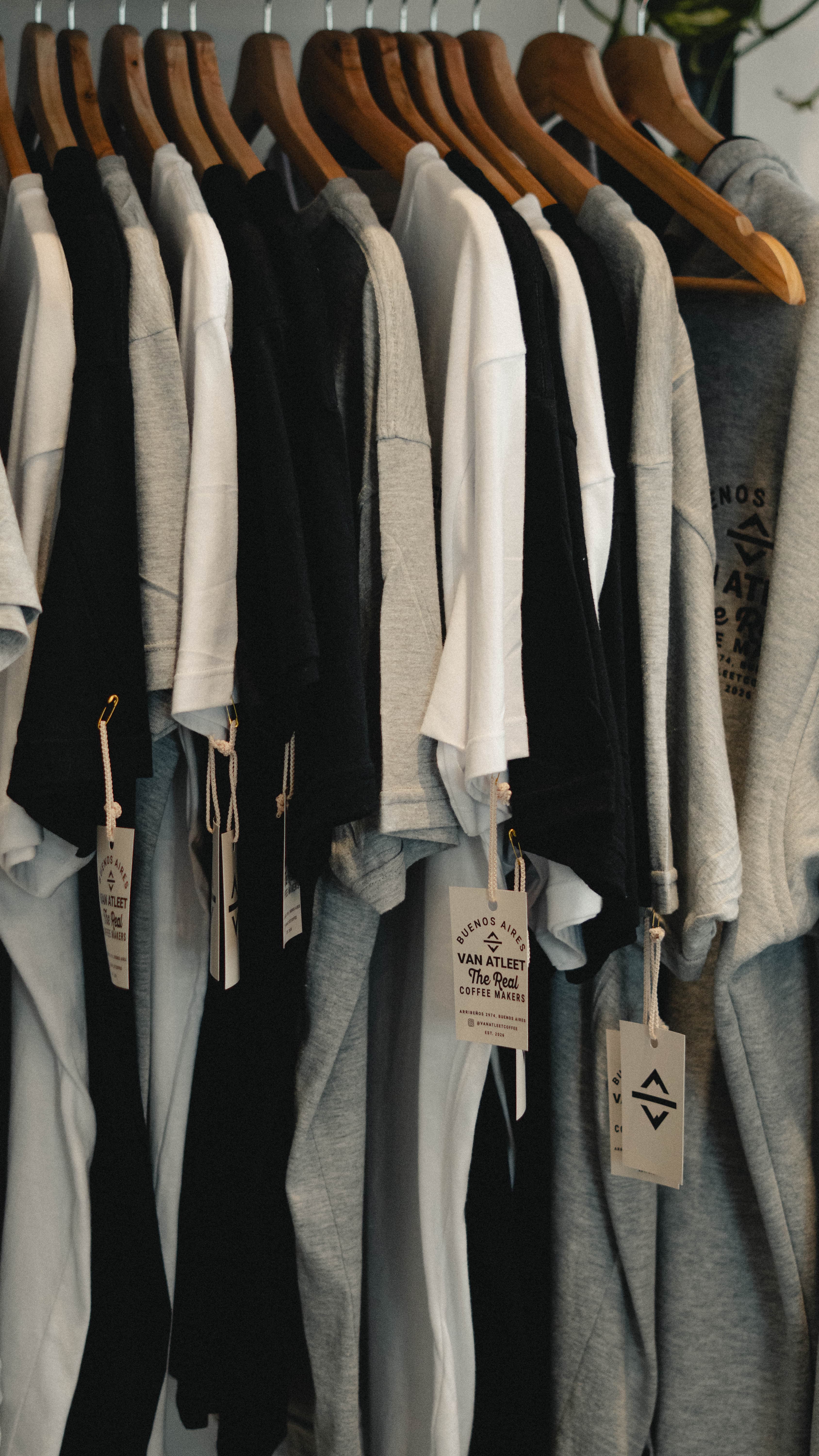 Van Atleet apparel hanging on wooden hangers