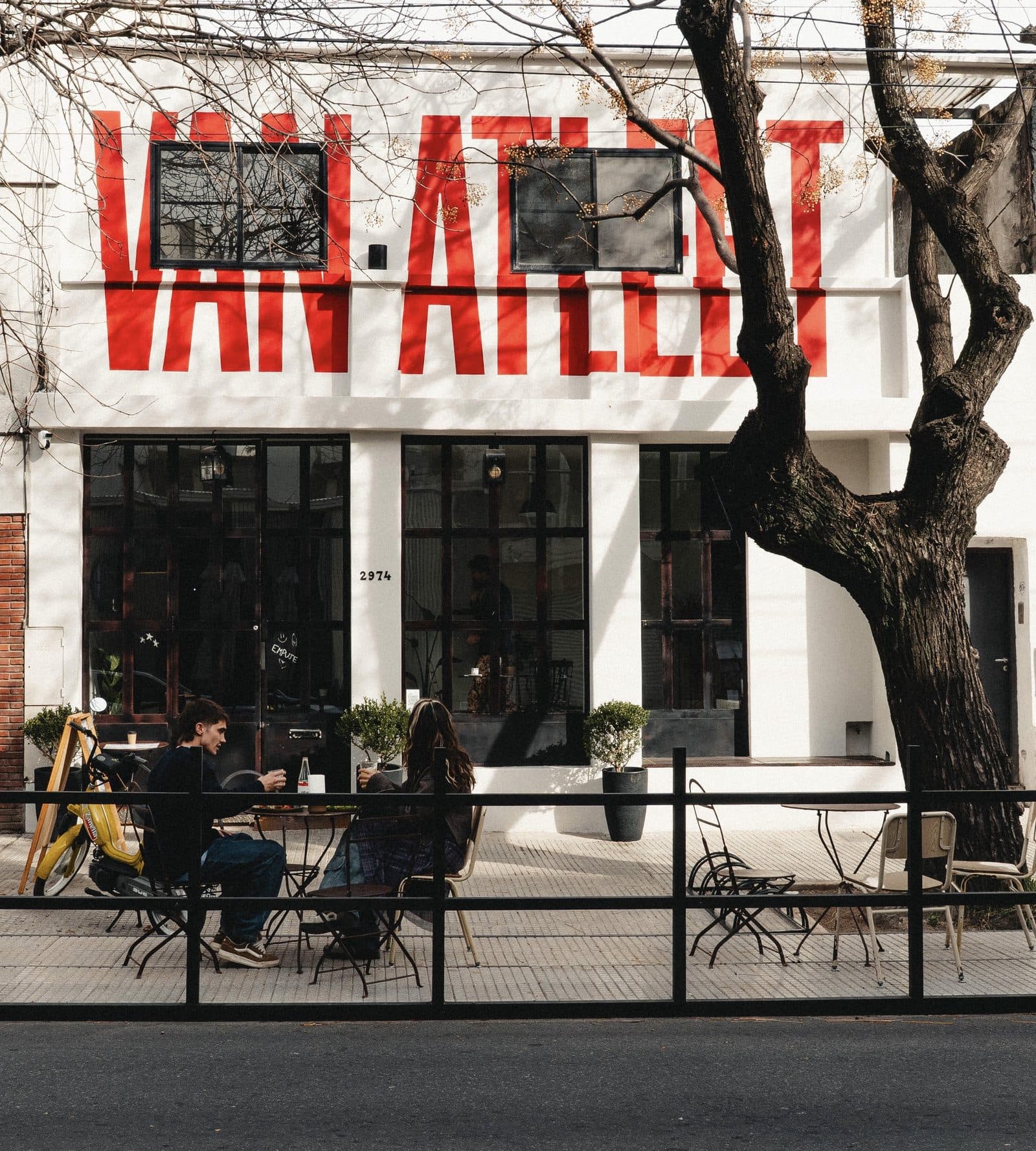 Mesas en la vereda del Van Atleet Coffee House, con el logo pintado en el frente