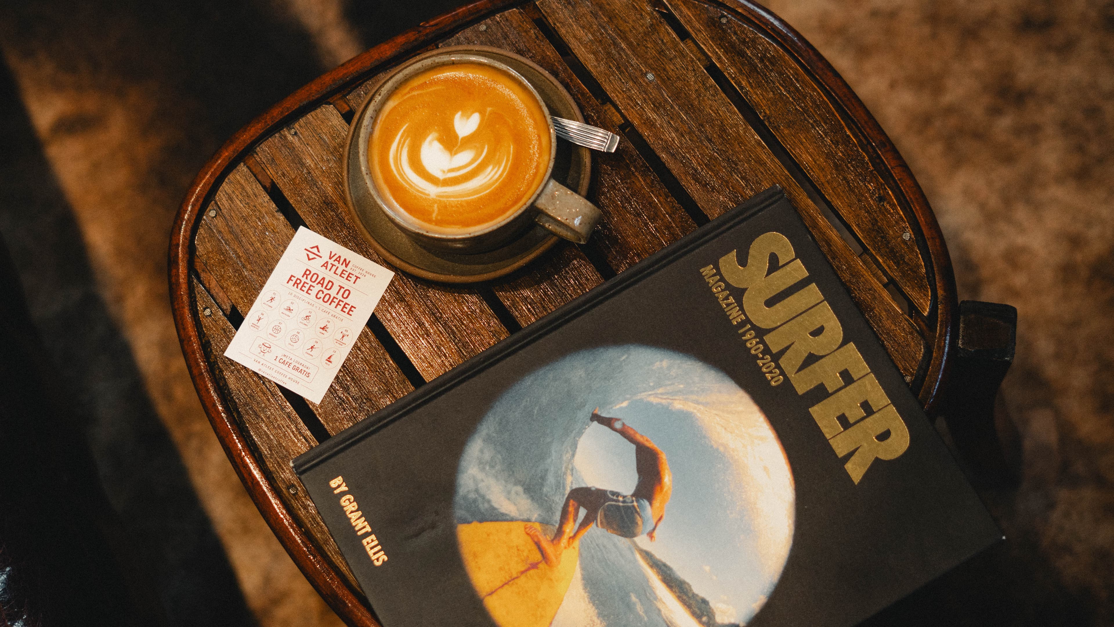 Latte and surf book on a side table