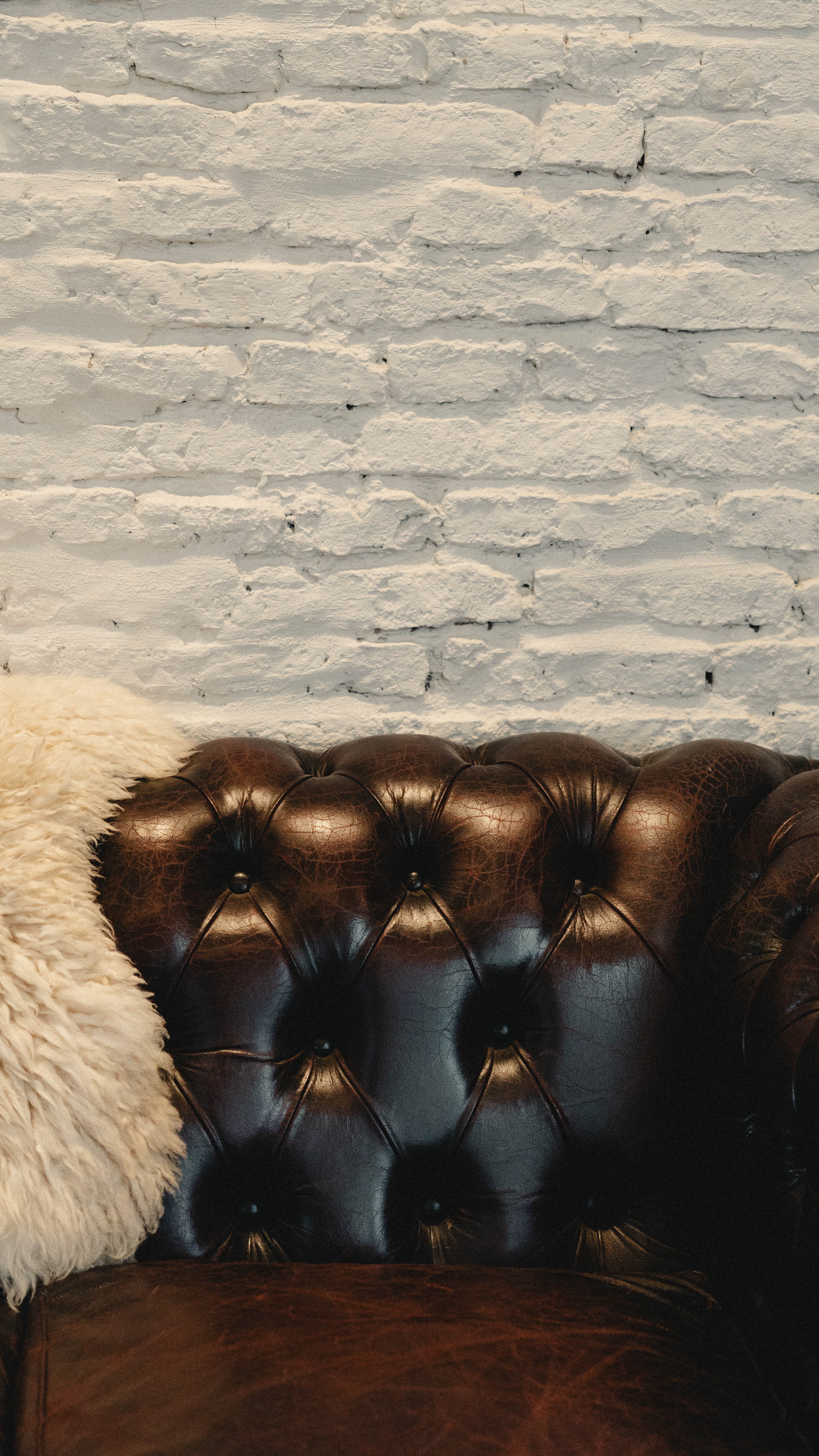 Chesterfield couch against the brick wall